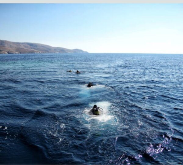 Group of scuba divers entering the open sea from a boat at the start of a drift dive in the Red Sea